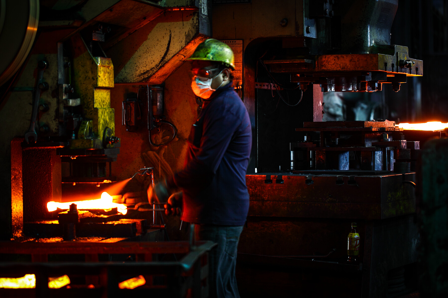Operator performing a hot forging process